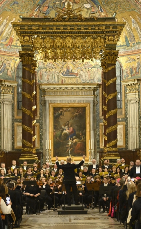 Maciej Tworek dyryguje orkiestrą i chórami podczas koncertu Credo w wypełnionej publicznością Bazylice Santa Maria Maggiore w Rzymie.